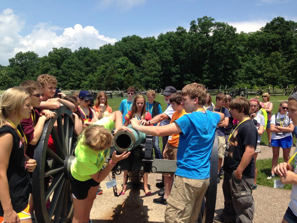 students examining an old fashioned cannon